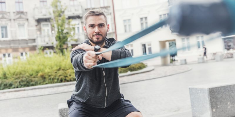 Man strengthening his arms in the city.